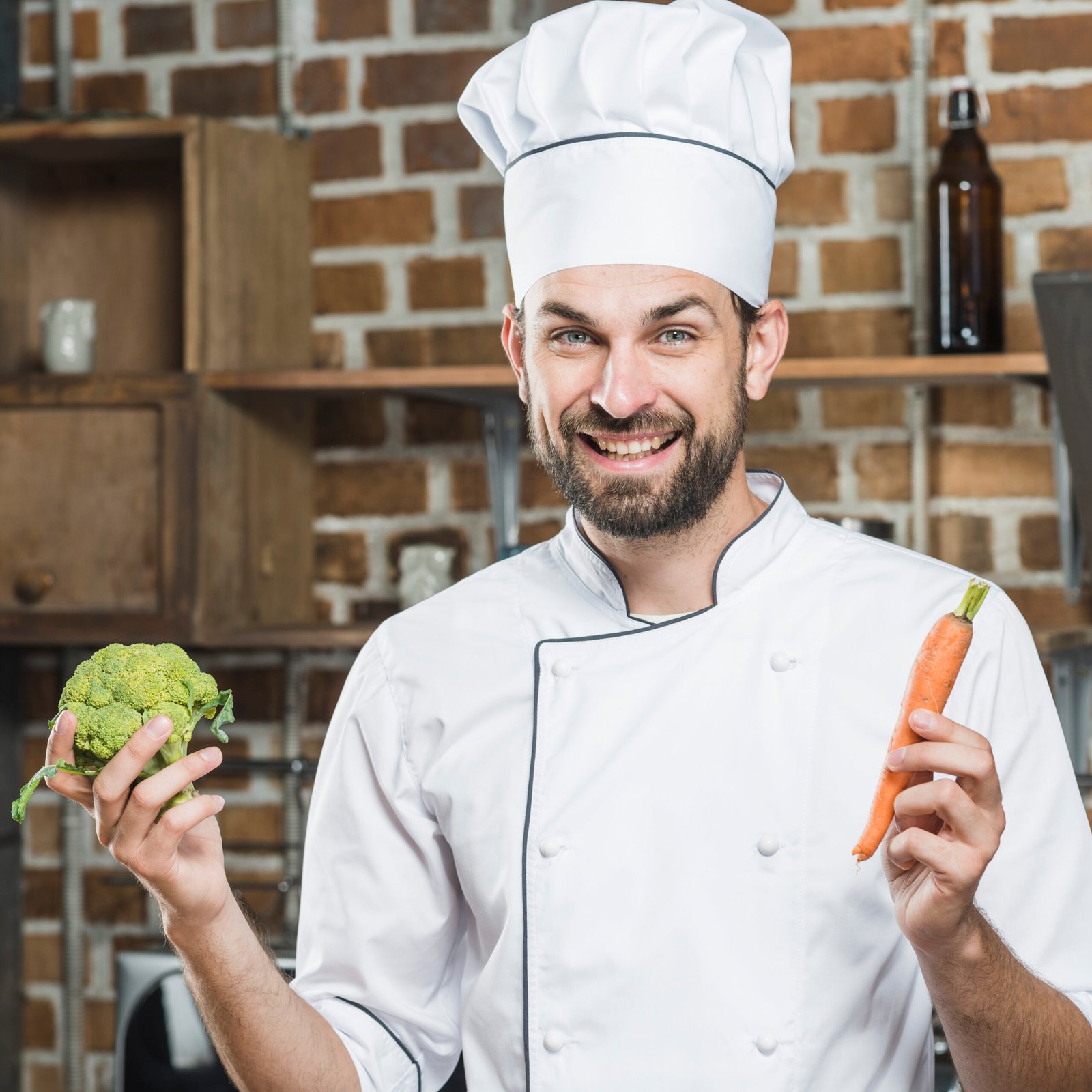 smiling-male-chef-holding-carrot-green-broccoli-hands